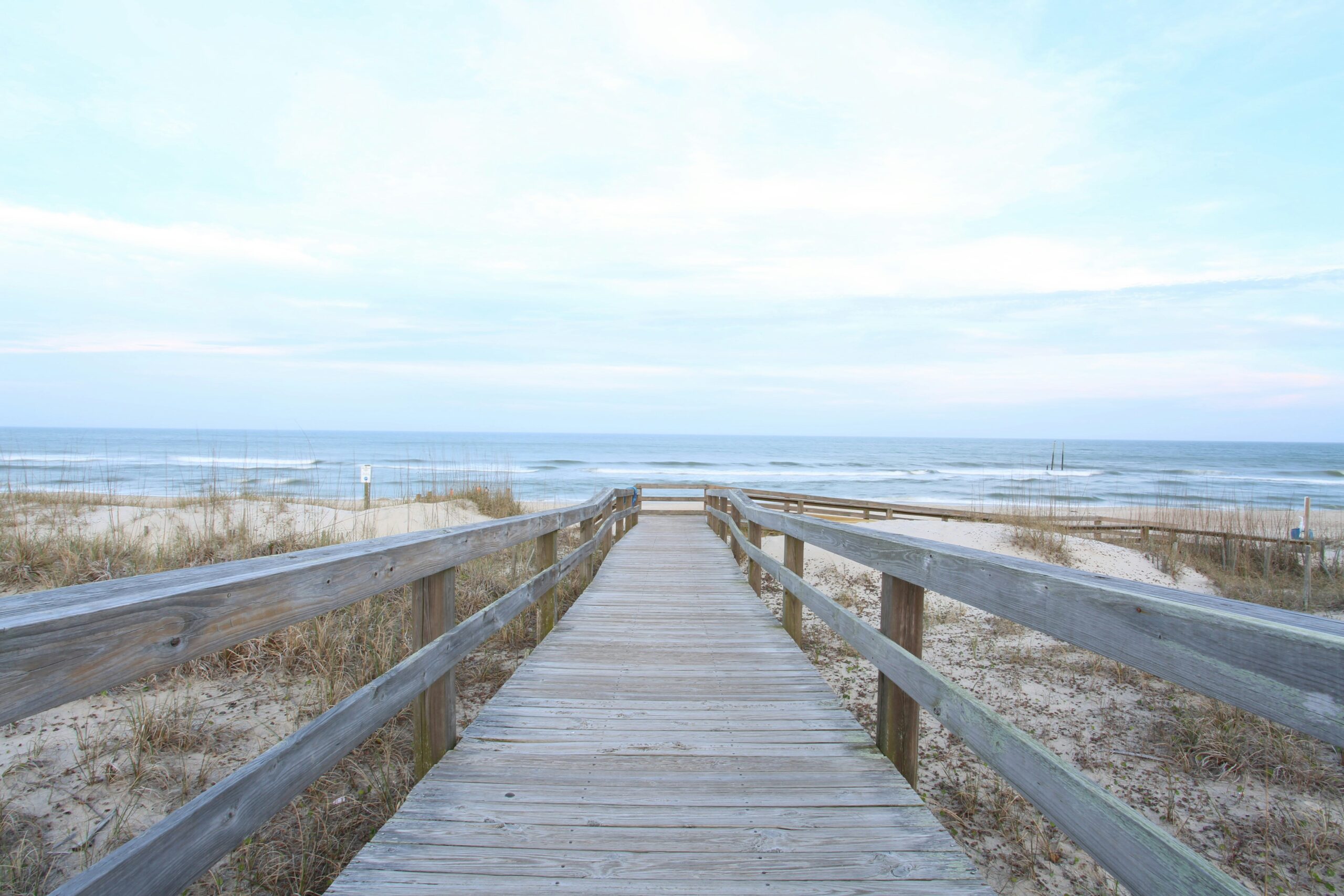 a wooden bridge leading to the ocean