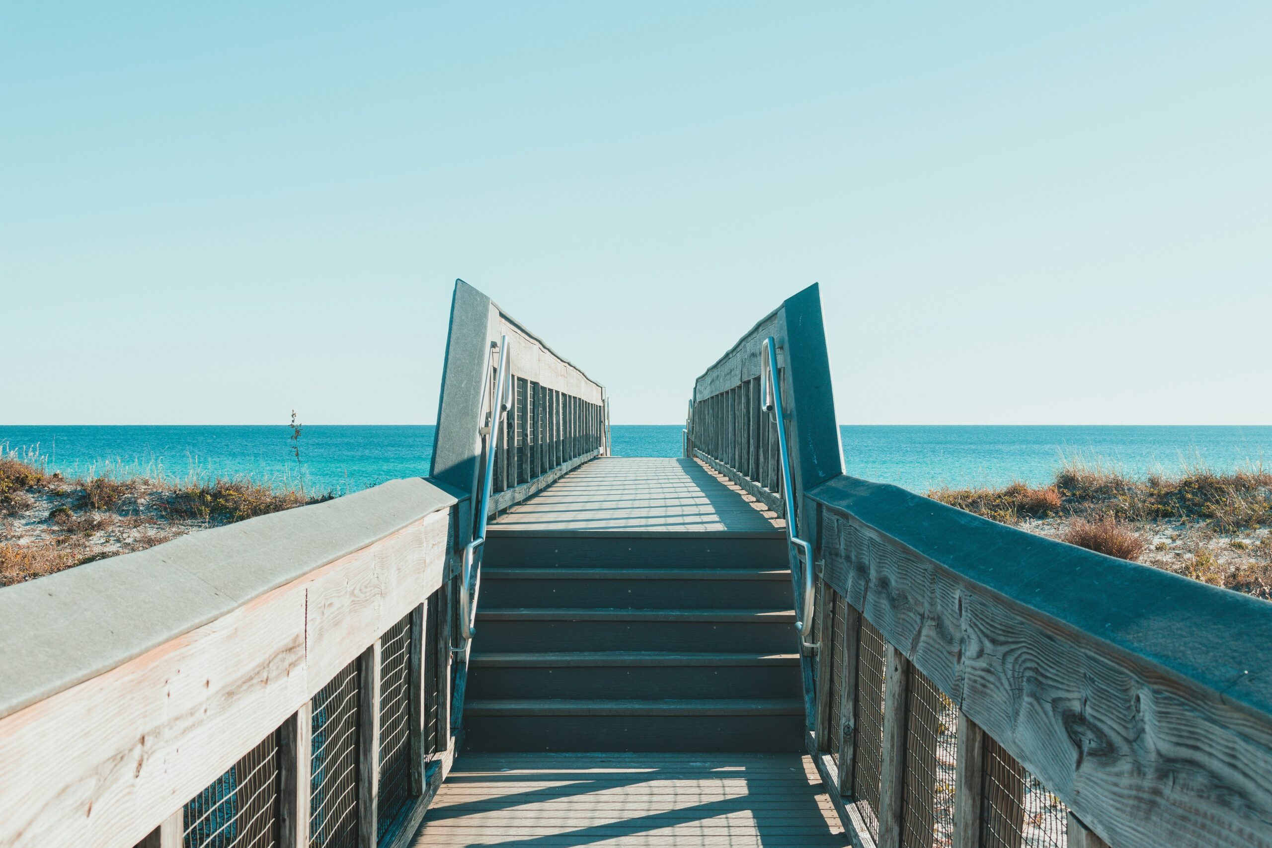 a wooden walkway to a beach